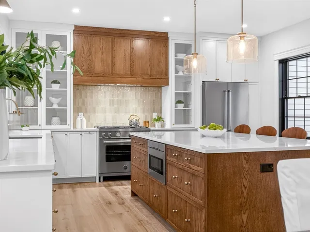 a kitchen with kitchen island granite countertop a sink a counter space appliances and cabinets