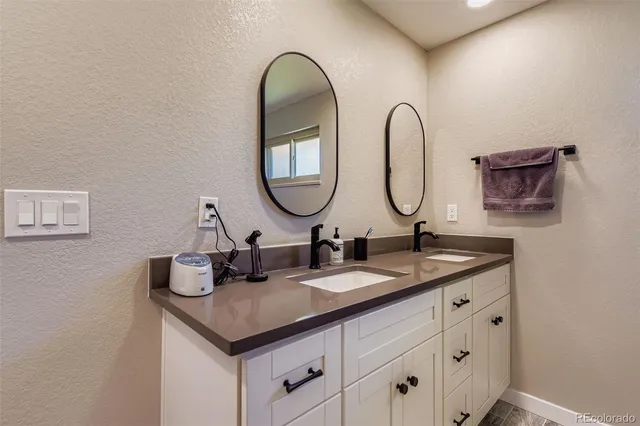a bathroom with a granite countertop sink and a mirror