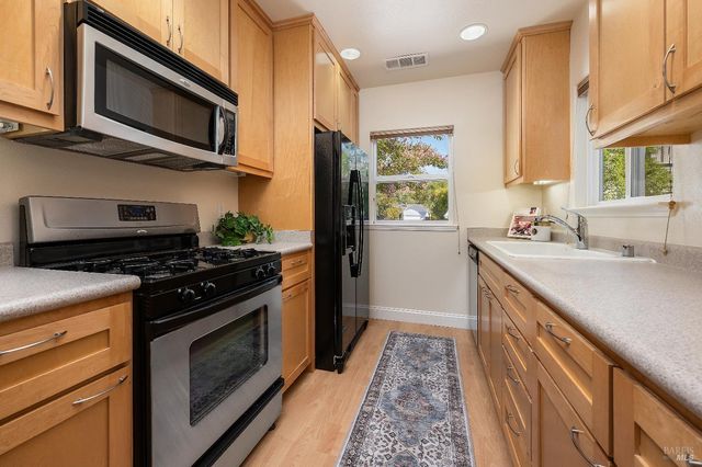 a kitchen with stainless steel appliances a stove a sink and a microwave