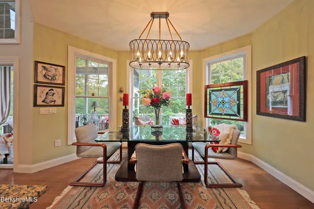a dining room with furniture a chandelier and wooden floor