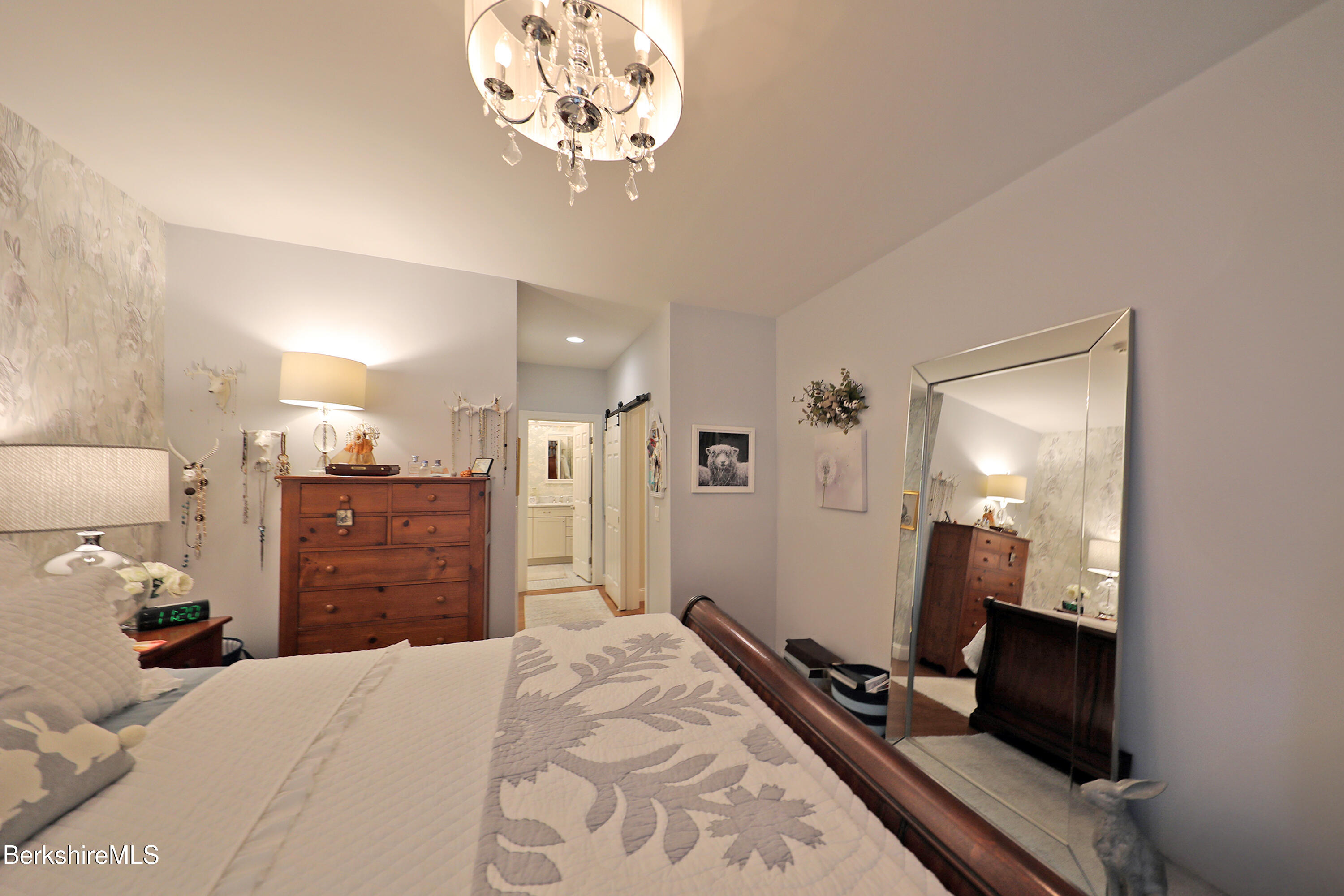 103 Alpine Trail Pittsfield, MA 01201 - Photo 20 of 39 a bedroom with a bed and a chandelier