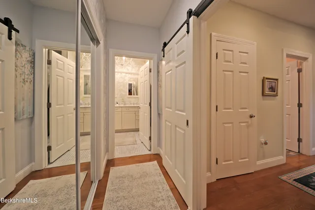 a view of a hallway with wooden floor and closet area