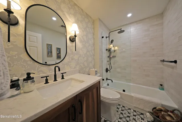 a bathroom with a sink a toilet and a mirror