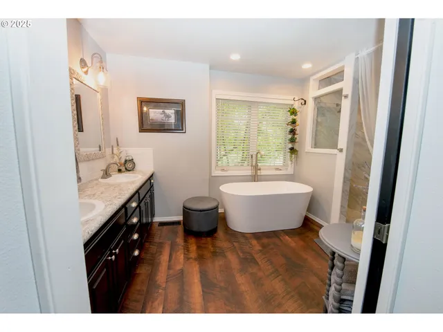 a spacious bathroom with a tub sink and mirror