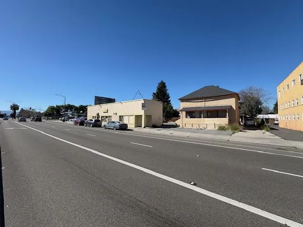 a view of a city street with a car parked on the street