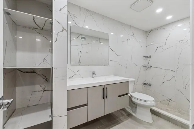 a bathroom with a toilet sink a mirror and shower
