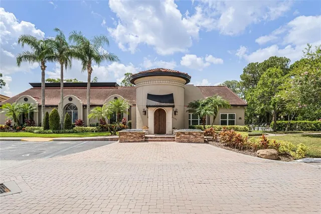 front view of a house with a yard and palm trees