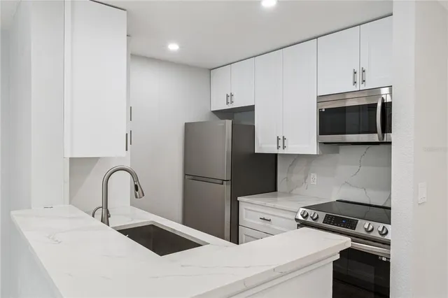 a kitchen with stainless steel appliances a refrigerator stove and microwave