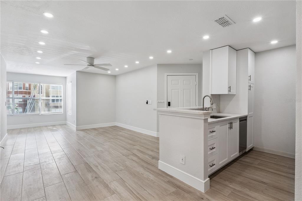 5124 Conroy Road, Unit 24 Orlando, FL 32811 - Photo 5 of 26 a kitchen with a sink wooden floor and white cabinets