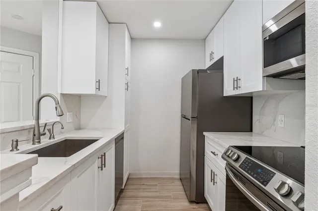 a kitchen with stainless steel appliances granite countertop a sink stove and refrigerator