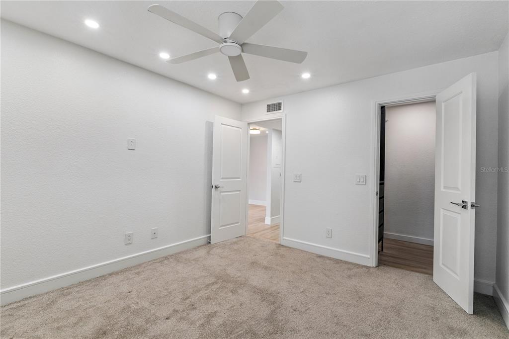 5124 Conroy Road, Unit 24 Orlando, FL 32811 - Photo 9 of 26 an empty room with a ceiling fan and a bathroom