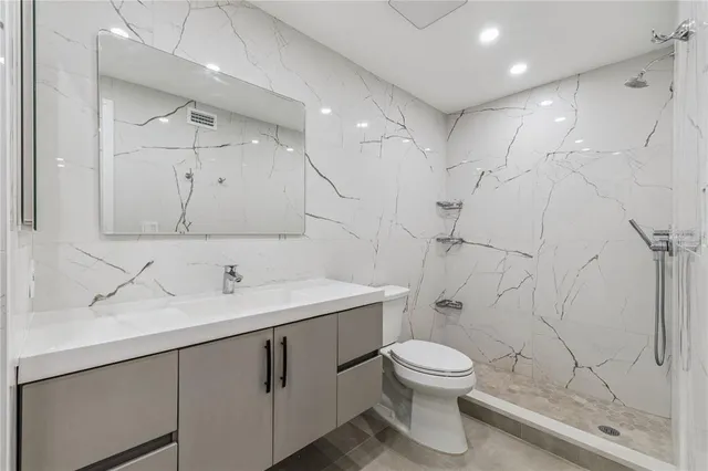 a bathroom with a toilet sink a mirror and shower