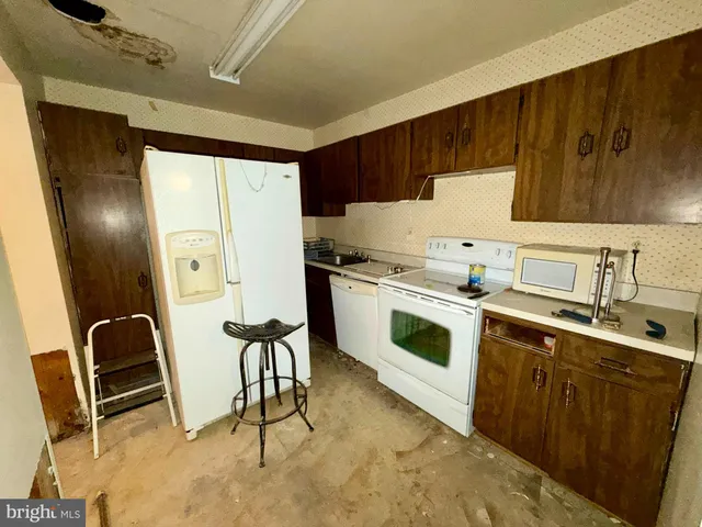 a kitchen with a stove a refrigerator and sink