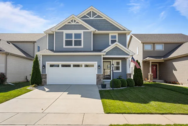 a front view of a house with a yard and garage