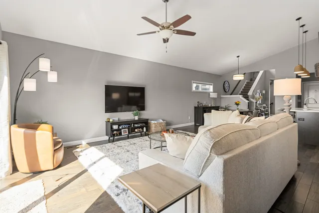 a living room with furniture a rug and kitchen view