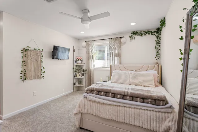 a bedroom with a bed chandelier and a window