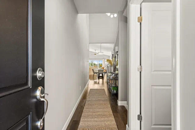 a view of a hallway with wooden floor and a bathroom