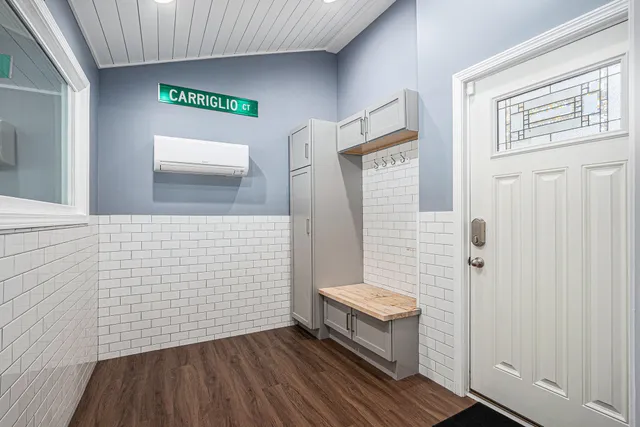 a view of a hallway with wooden floor and a bathroom