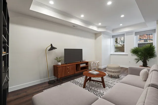 a living room with furniture a flat screen tv and wooden floor