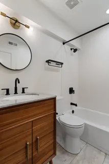 a bathroom with a toilet a sink and mirror