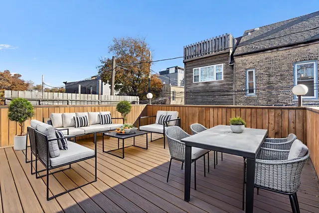 a view of a roof deck with table and chairs