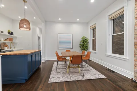 a dining room with wooden floor and window
