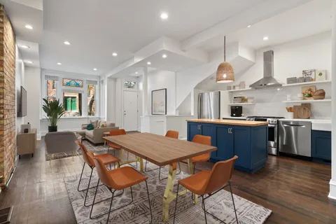 a kitchen with stainless steel appliances kitchen island granite countertop a kitchen island a stove a table and chairs