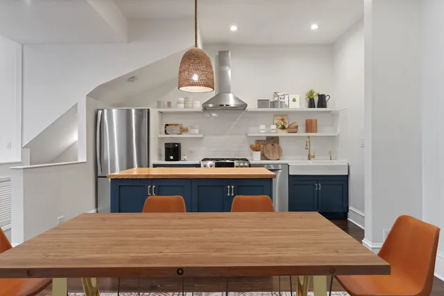 a kitchen with a stove a refrigerator and wooden floor
