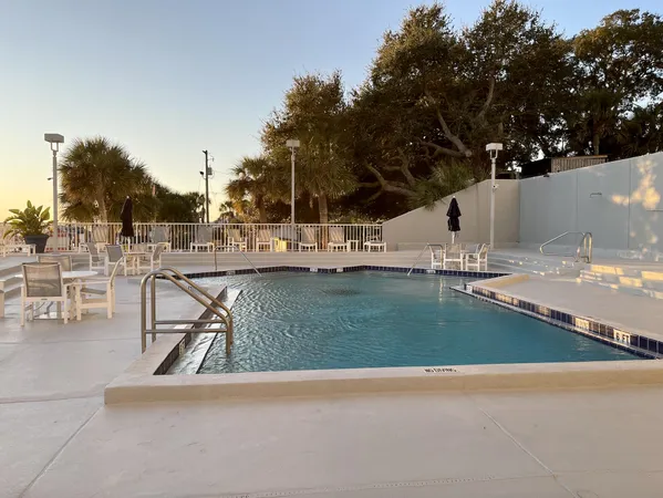 a view of a swimming pool with a slide and bench