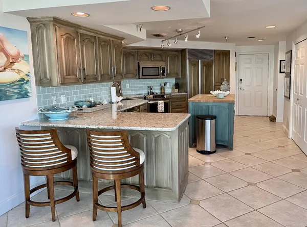 a kitchen with cabinets and chairs