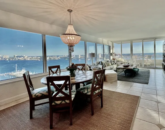 a view of a dining room and livingroom with furniture wooden floor a chandelier