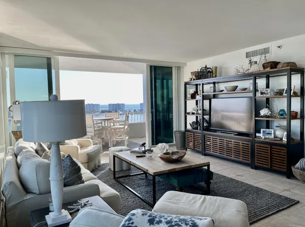 a living room with furniture a rug and a floor to ceiling window