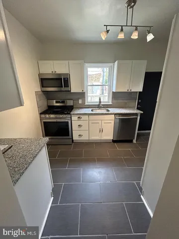 a kitchen with a sink a stove a microwave and cabinets