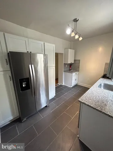 a kitchen with a refrigerator a sink and cabinets