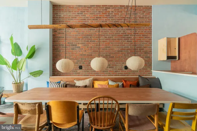 a dining room with furniture and a kitchen area