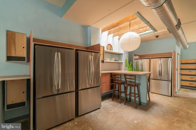 a table with chairs in it and wooden floor