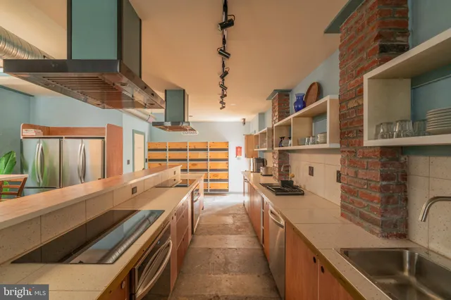 a kitchen with stainless steel appliances granite countertop a sink a stove and a wooden floors