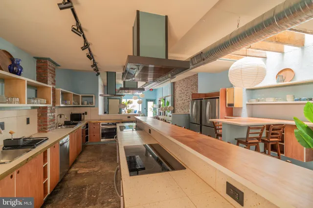 a kitchen with kitchen island granite countertop a sink stove and cabinets