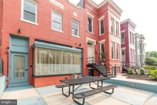 a view of a brick building with a bench in front of building