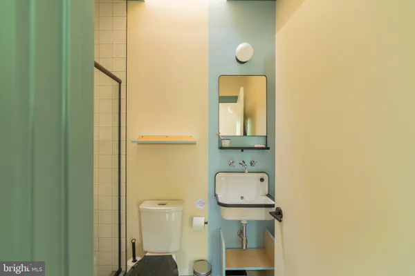 a bathroom with a toilet a sink and mirror