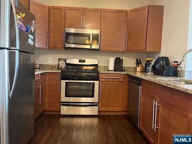 a kitchen with stainless steel appliances granite countertop a refrigerator microwave and sink