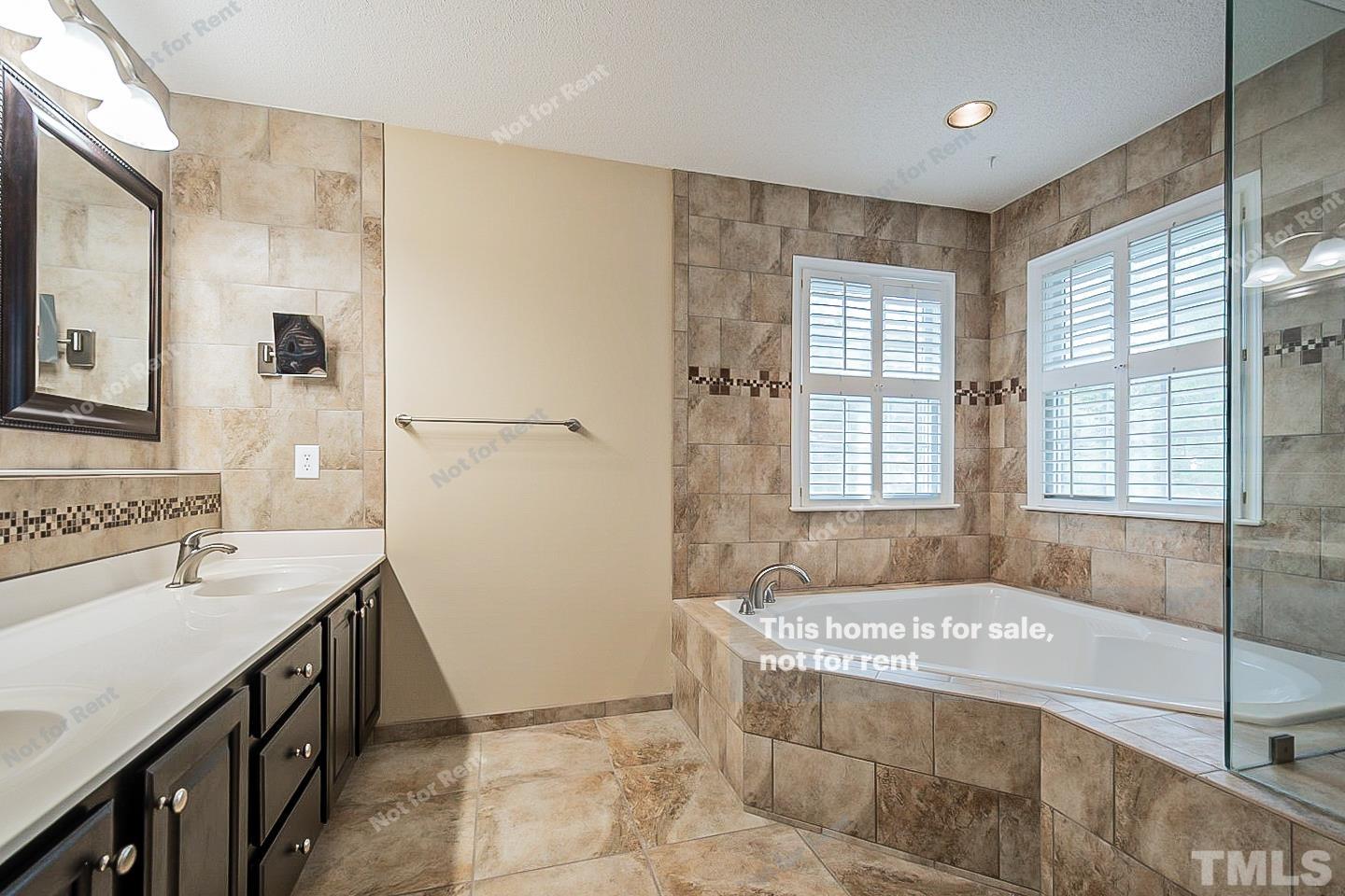 3300 Stone Castle Court Raleigh, NC 27613 - Photo 18 of 24 a spacious bathroom with a tub sink and mirror