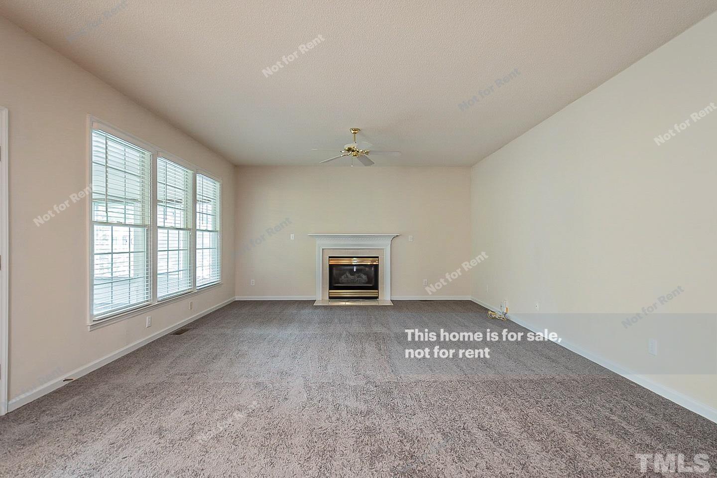 3300 Stone Castle Court Raleigh, NC 27613 - Photo 3 of 24 a view of an empty room with a fireplace and a window