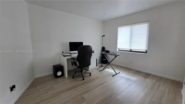 a view of a workspace with furniture and a window