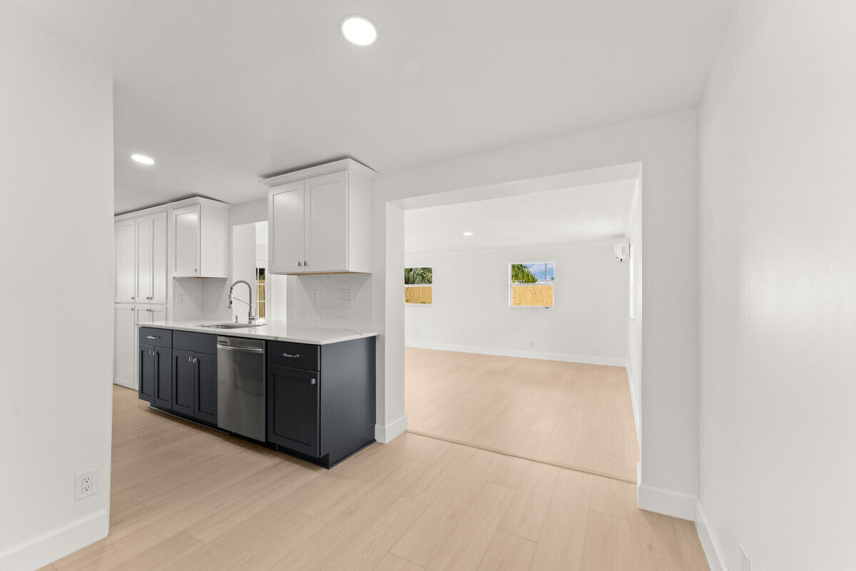 3797 Bahama Road Palm Beach Gardens, FL 33410 - Photo 22 of 27 a large kitchen with a lot of cabinets and wooden floor