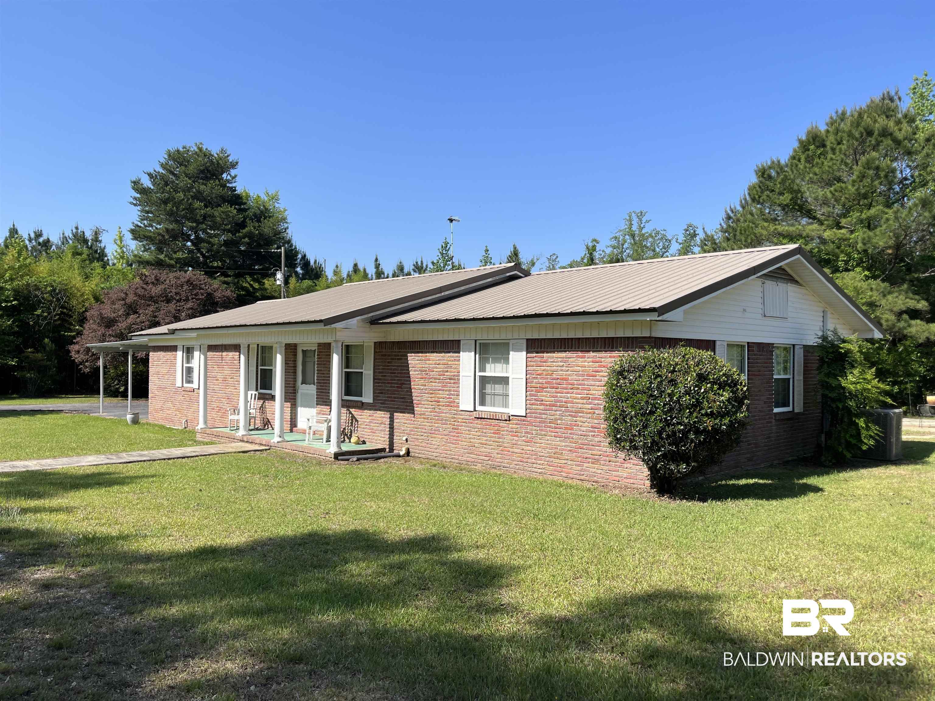 315 Dawkins Road Brewton, AL 36426 - Photo 3 of 19 Ranch-style house with metal roof, brick siding, and a front lawn