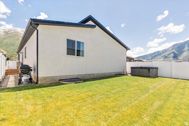 3916 South Sage Wood Avenue Mapleton, UT 84664 - Photo 30 of 33 Spacious backyard featuring a manicured lawn, white privacy fencing, and a built-in spa