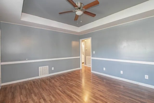 a view of an empty room with window and wooden floor
