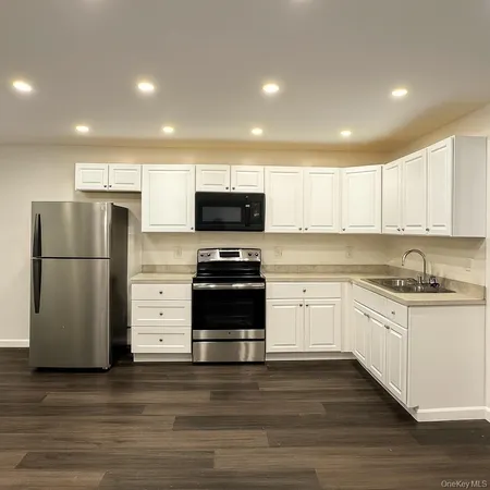 a kitchen with granite countertop a refrigerator stove and oven