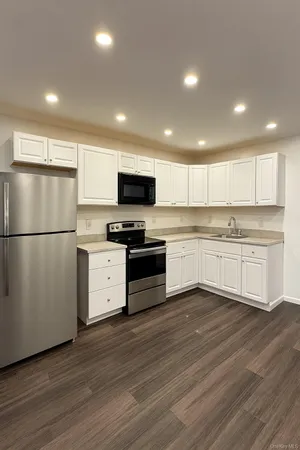 a kitchen with a refrigerator and a stove top oven